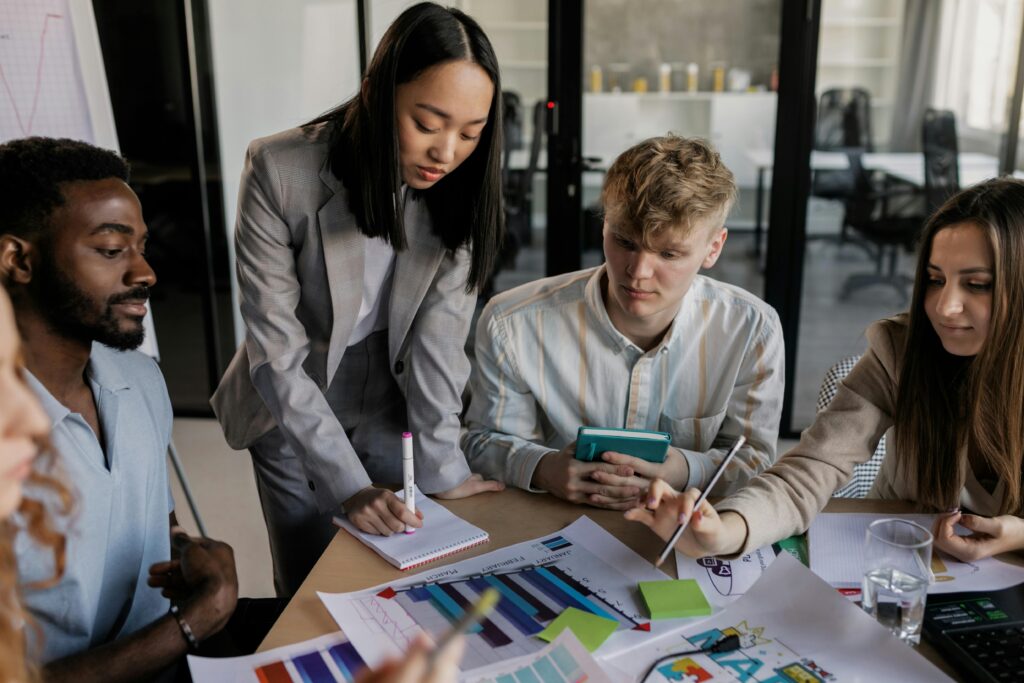 Team of young professionals collaborating over charts and graphs at a meeting table